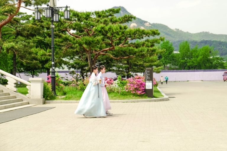 woman in white wedding dress standing near green tree during daytime
